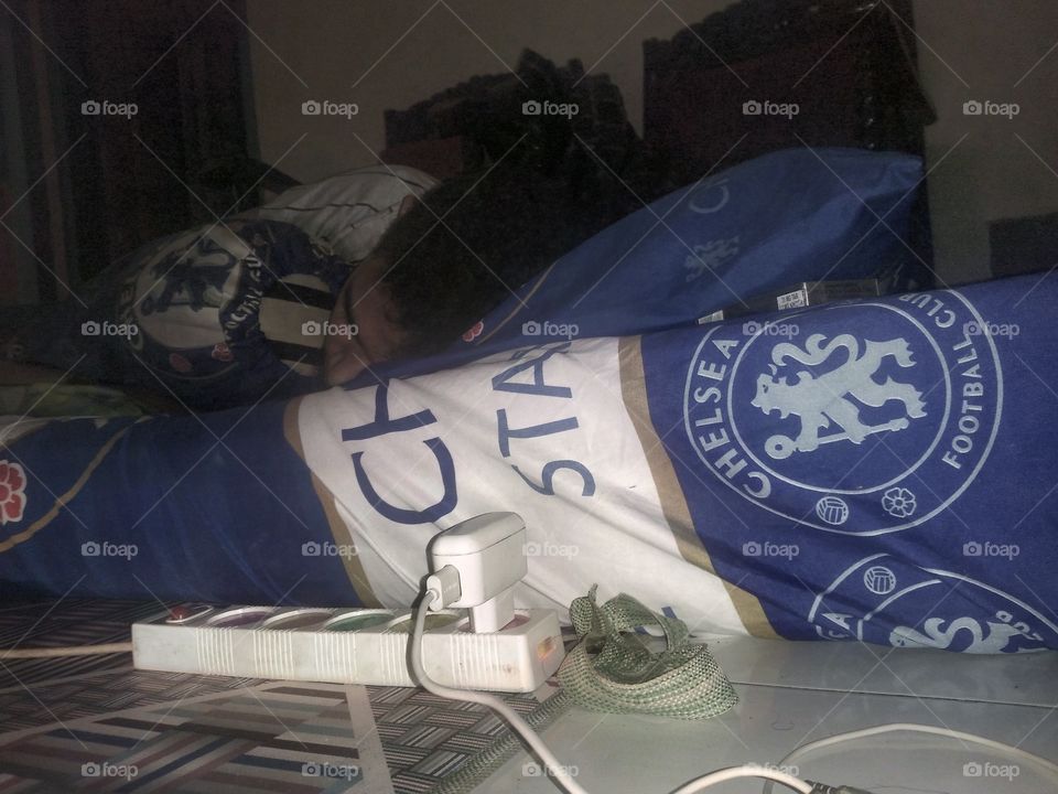 someone else sleeps on a bed with Chelsea cloth, a famous football club in Europe, this kid is a fan with Chelsea until all in blue