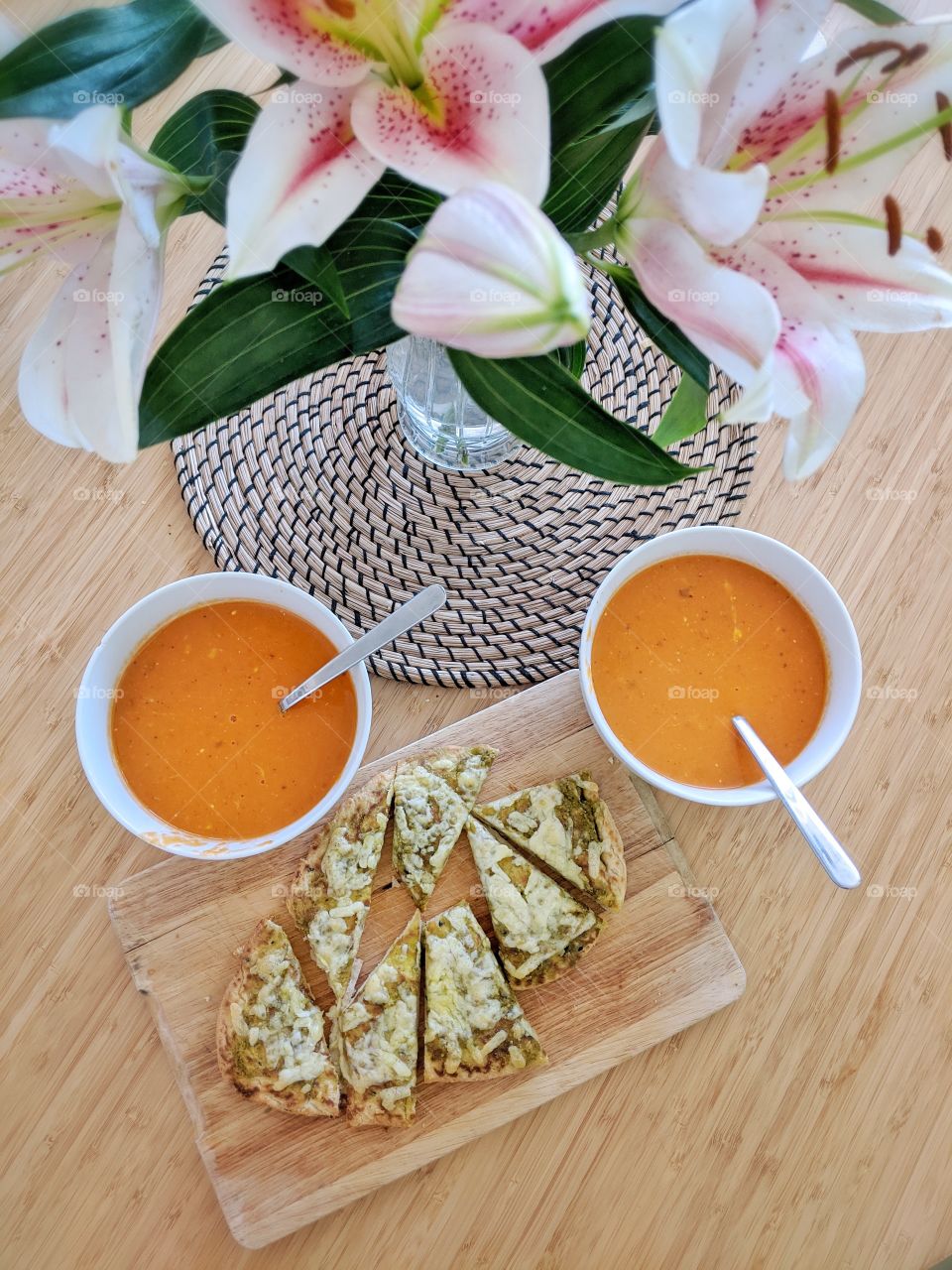 A rich and smooth cream tomato soup with a crunchy naan bread topped with pesto and cheddar