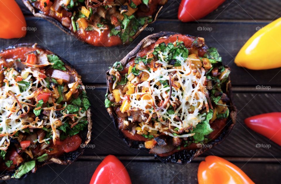 Homemade portobello mushrooms filled with red sauce, peppers, spinach and topped with shredded mozzarella cheese.