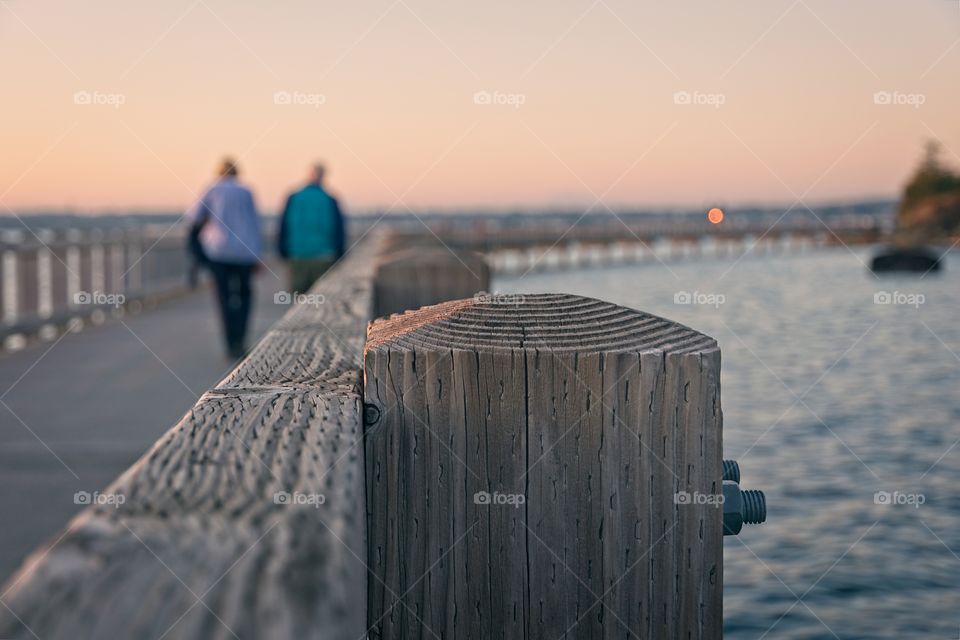 Couple walking on a bridge during sunset