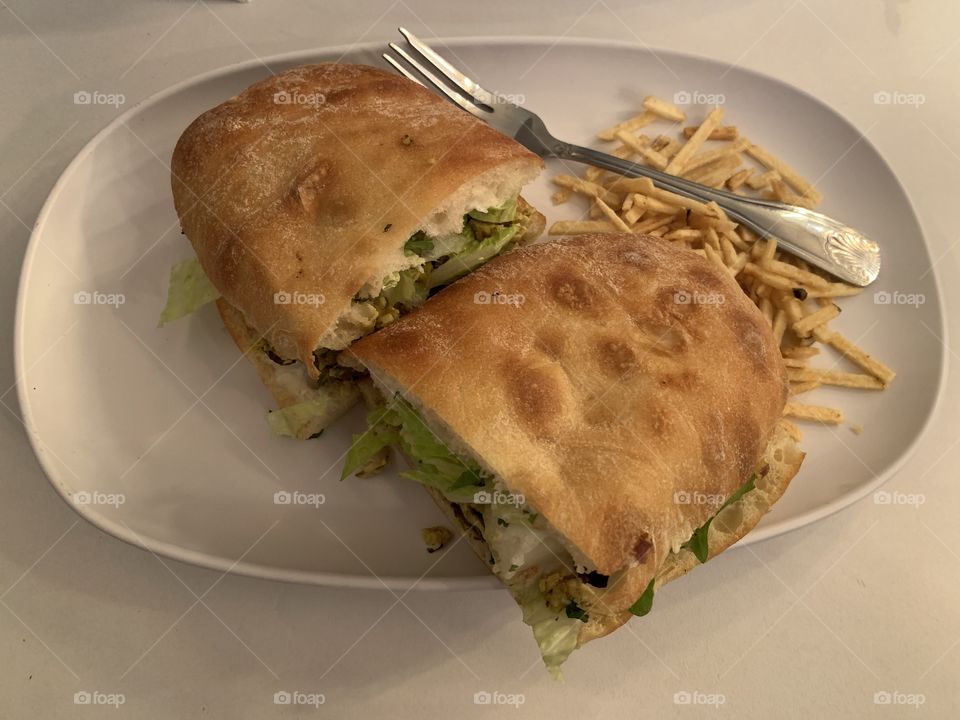 Two slice of chicken curry sandwich on an oblong white plate. 