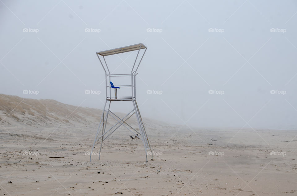 lonely lifeguard chair at the beach in the mist