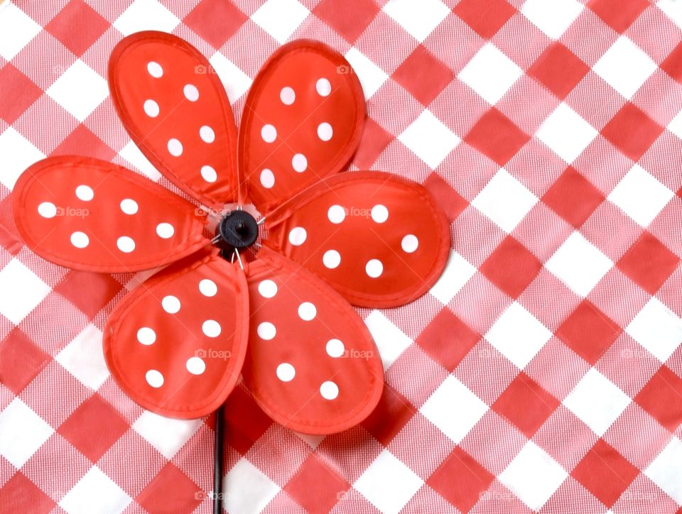 Red polka dot pinwheel on a red plaid background 