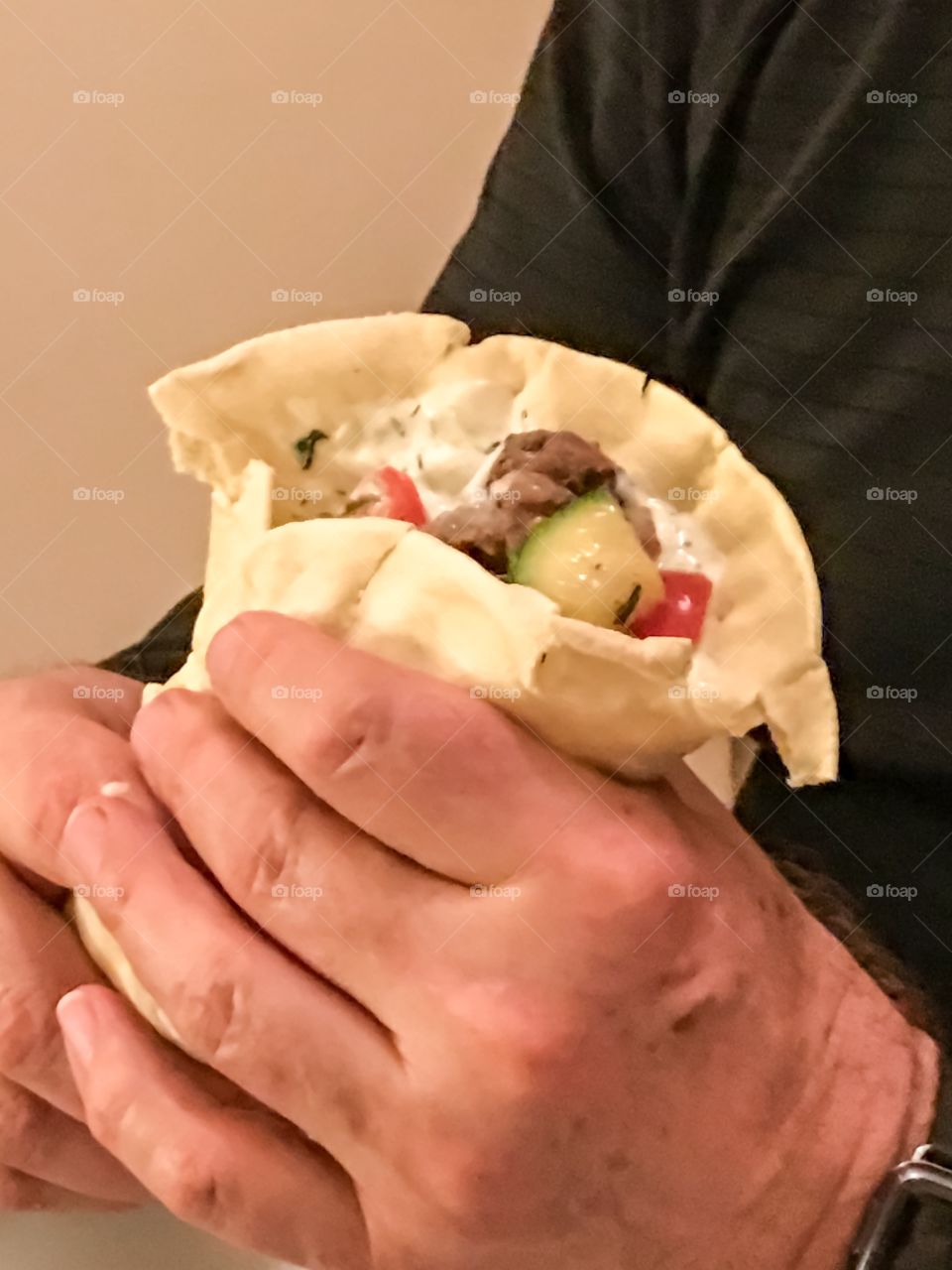 Burrito soft taco in man's hand Mexican food