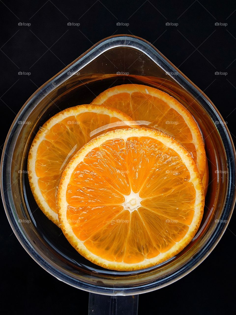 Sliced ​​oranges in a jug of water.  Toning and vitamin drink