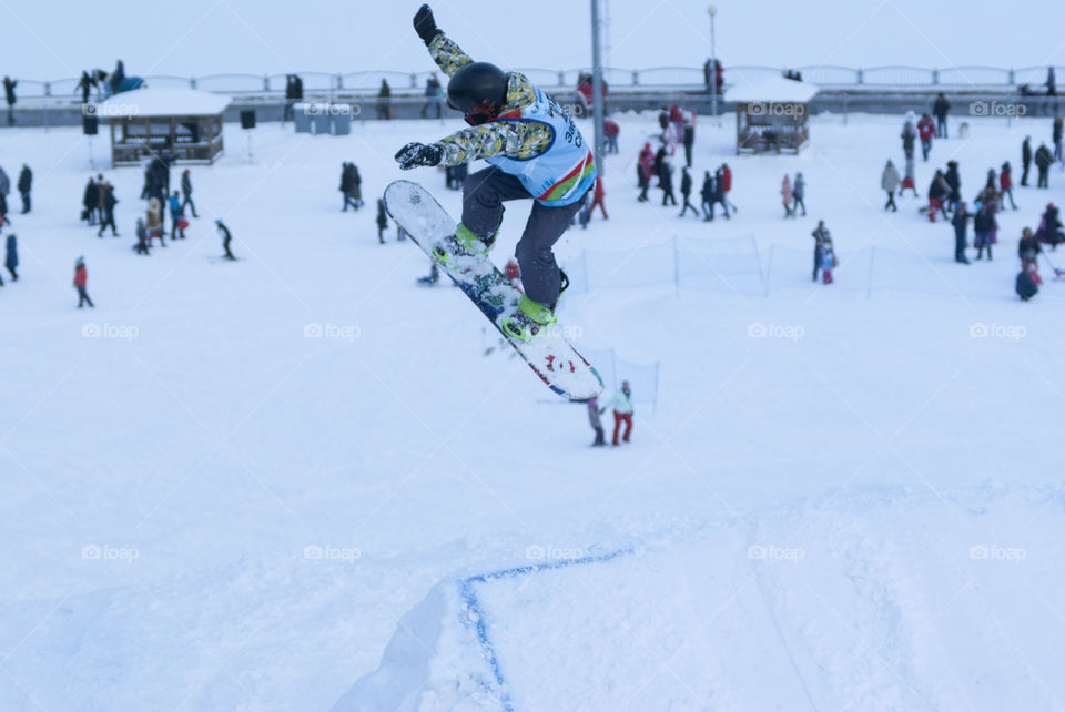 a men jamps on a snowboard