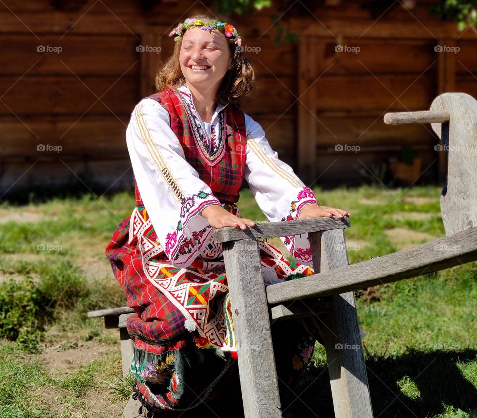 Natural Bulgarian woman in traditional clothes playing outside