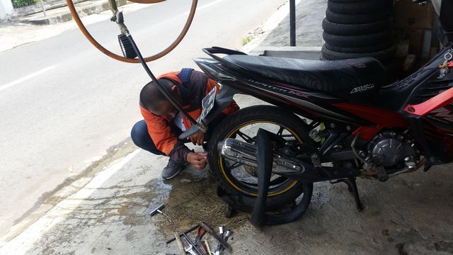 a mechanic who is repairing a motorbike
