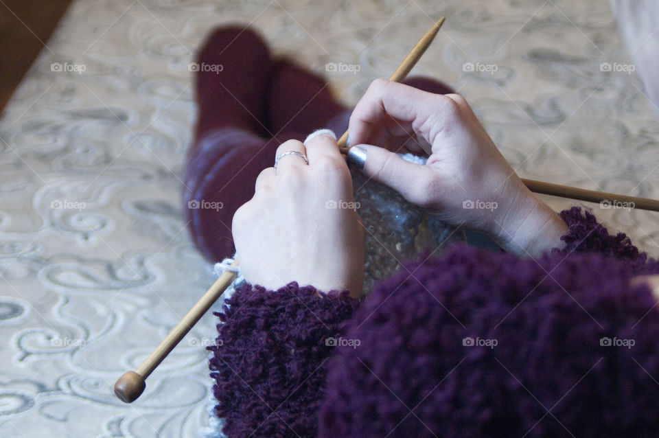 Girl knits on knitting sweater