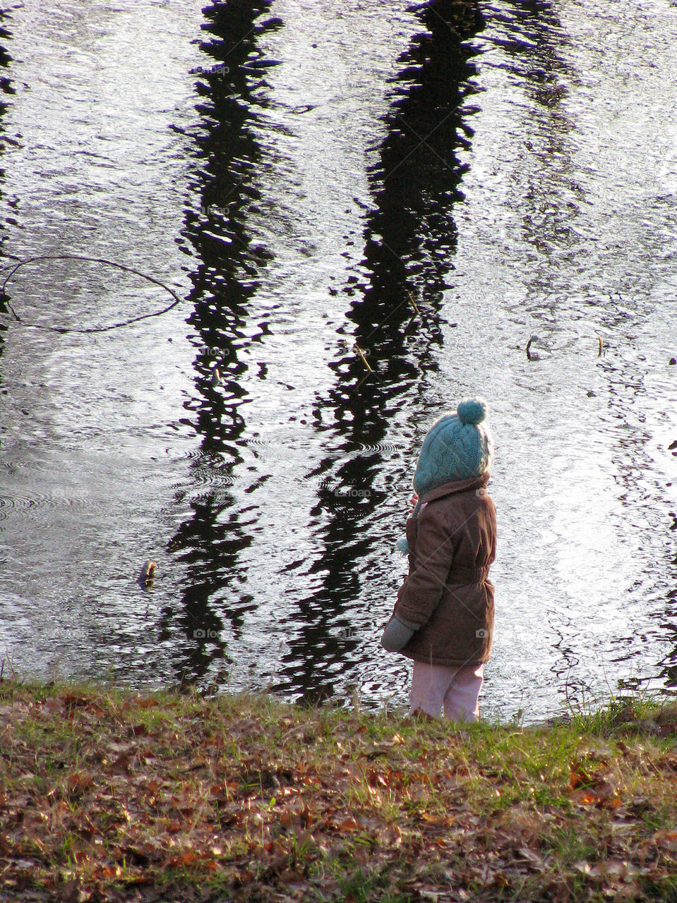 Little girl has fun at the lake in the fall