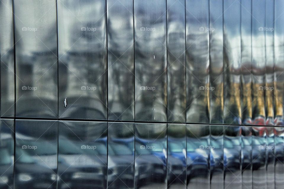 Close-up of a shiny house facade reflecting parked cars