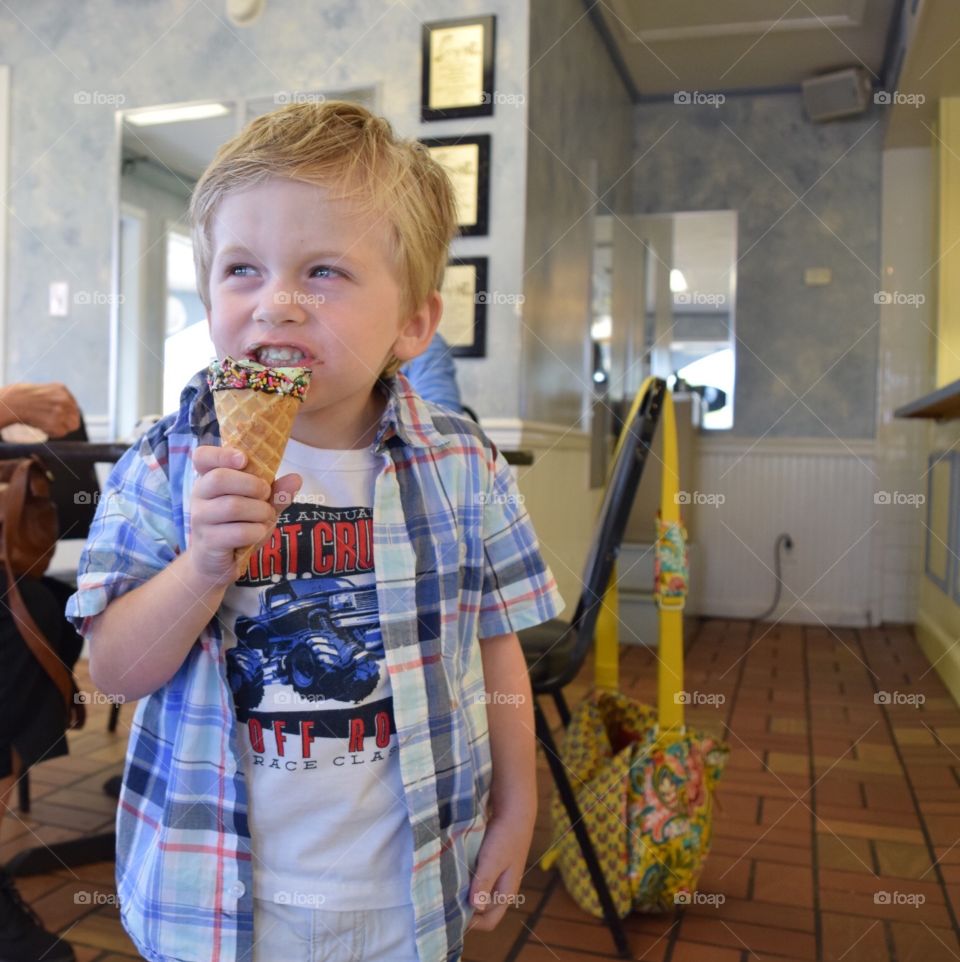 Boy enjoying his ice cream. Three year old and brain freeze