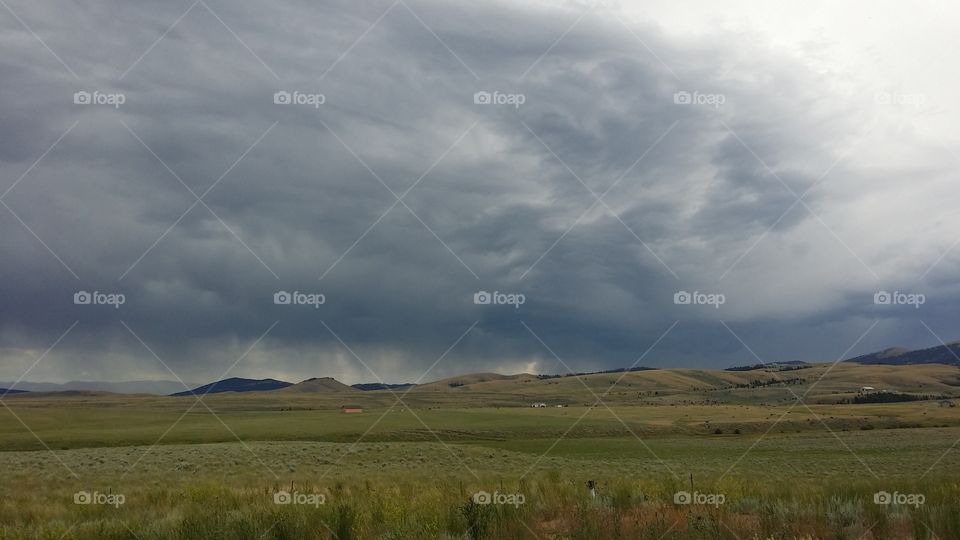 Storm clouds dump rain in the horizon hills in Big Sky country Montana. 