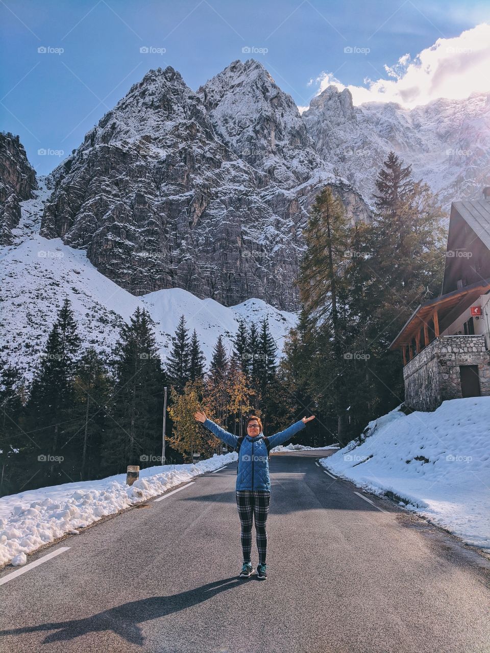 Young happy woman traveler against the snow covered Alps mountains in Slovenian trip.