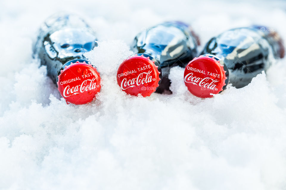 Three ice cold bottles of Coca Cola in the snow 