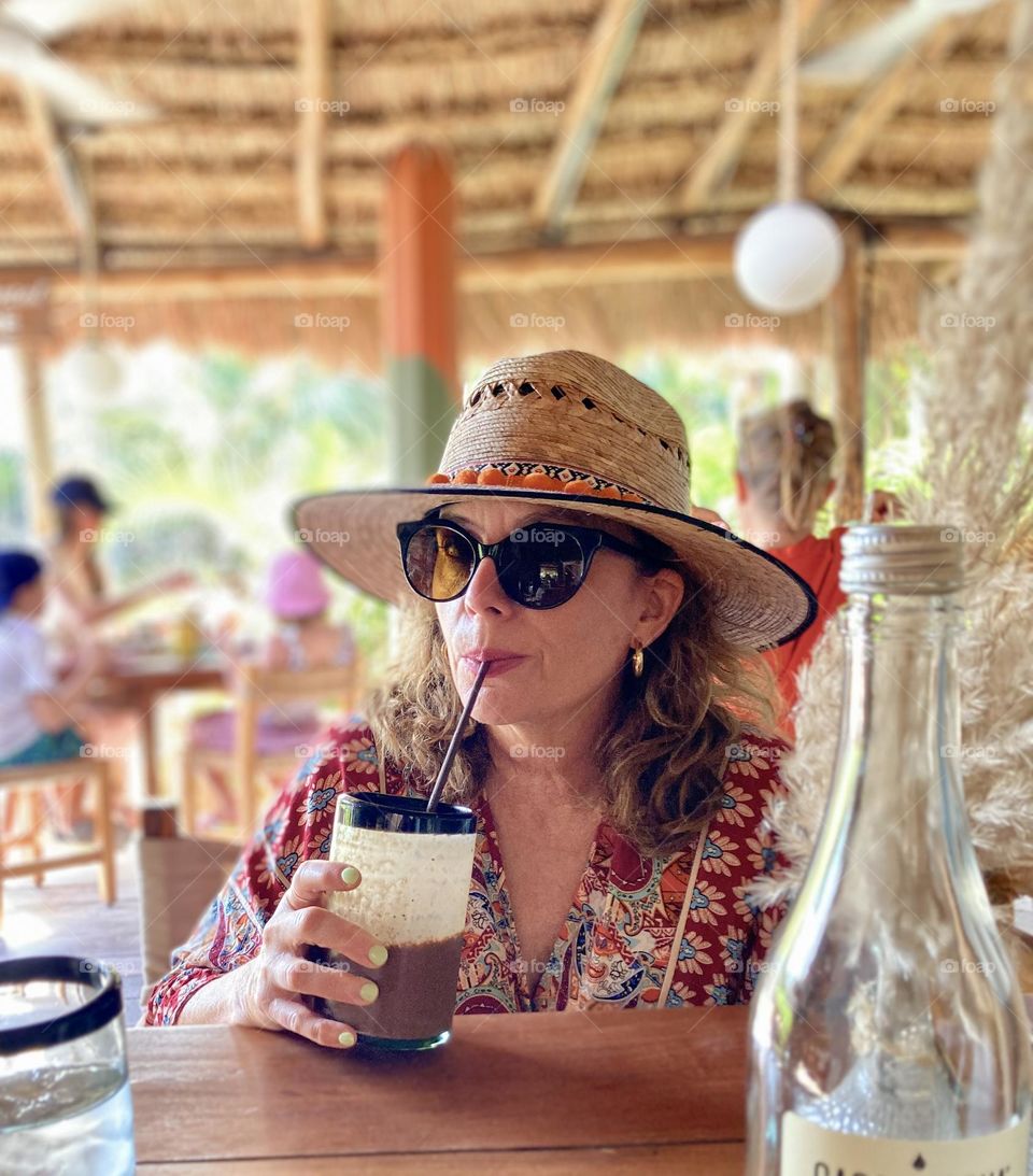 Beautiful woman enjoys a chocolate based smoothie.