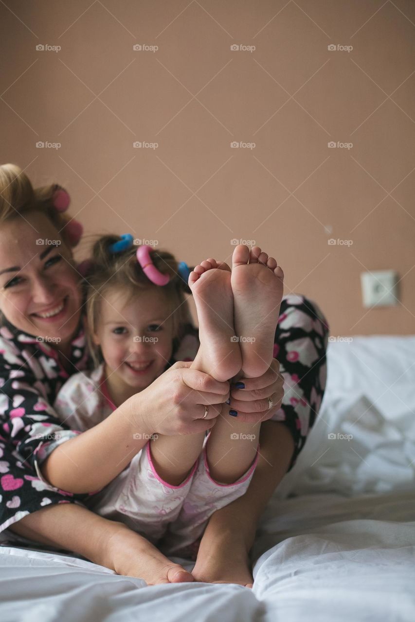 beautiful mother and her daughter spend time together at home. Gentle and warm attitude, girls have fun, hug and make themselves beautiful