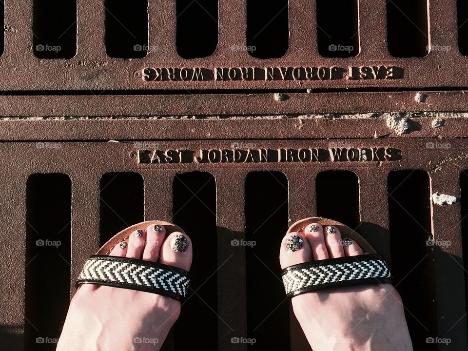 Patterned shoes, textured nails, and rusty drain