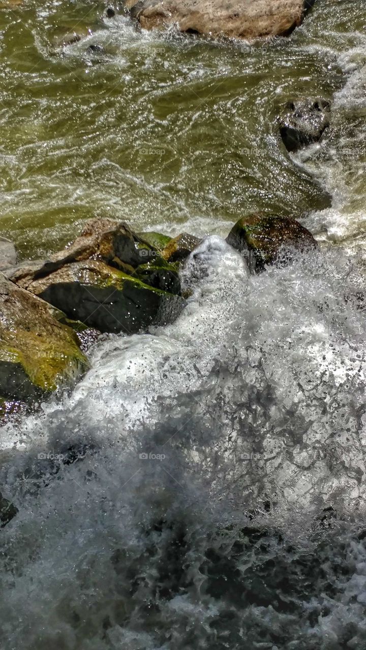 Swirling waters of the Colorado river collide against boulders on their way through the canyon.