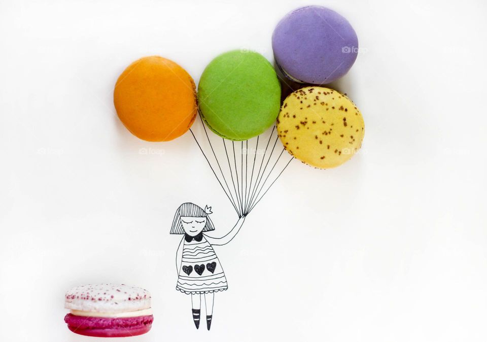 Drawing of girl holds real circle shaped macaroons