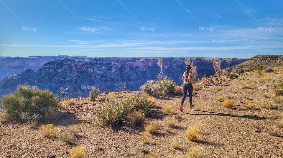 beautiful woman runs by Grand canyon