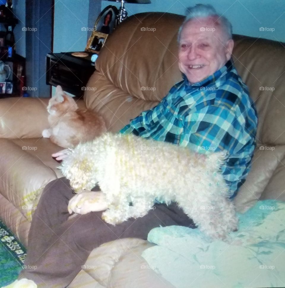 Grandfather on couch with cat & dog.