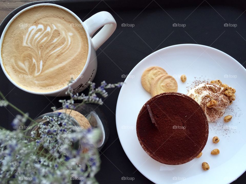 Cappuccino coffee with biscuits on table