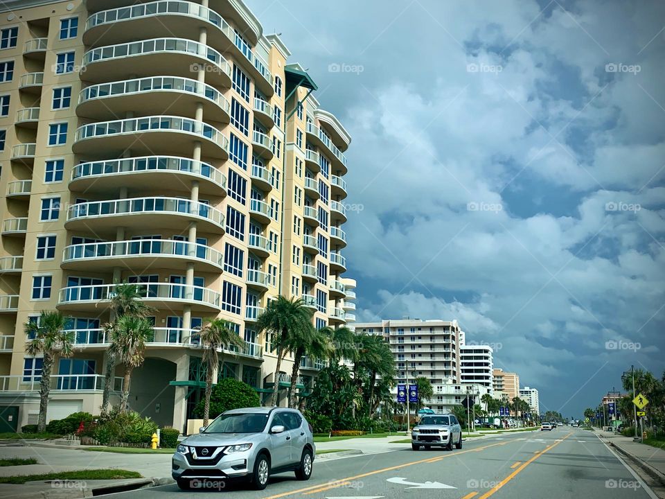 Commuting: vehicles driving in the opposite direction by apartment buildings in the city roads on a cloudy day.