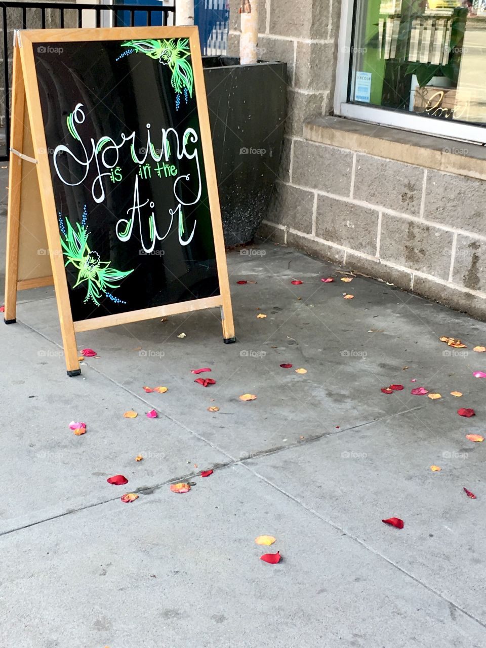 Downtown flower shop sign announcing spring.