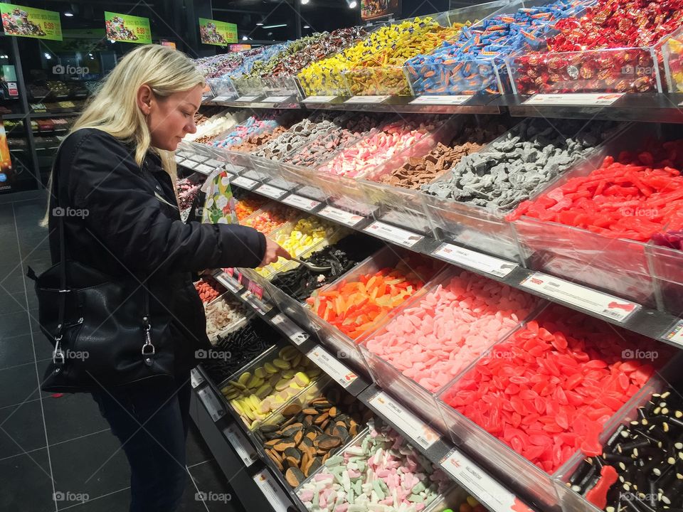 Young woman pickung up some candy in a local store in Malmö Sweden.