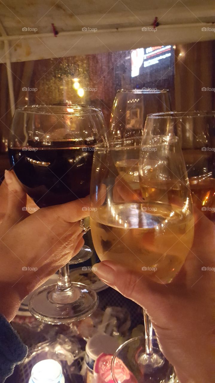 Friends celebrate by toasting with a variety of wine in glasses.