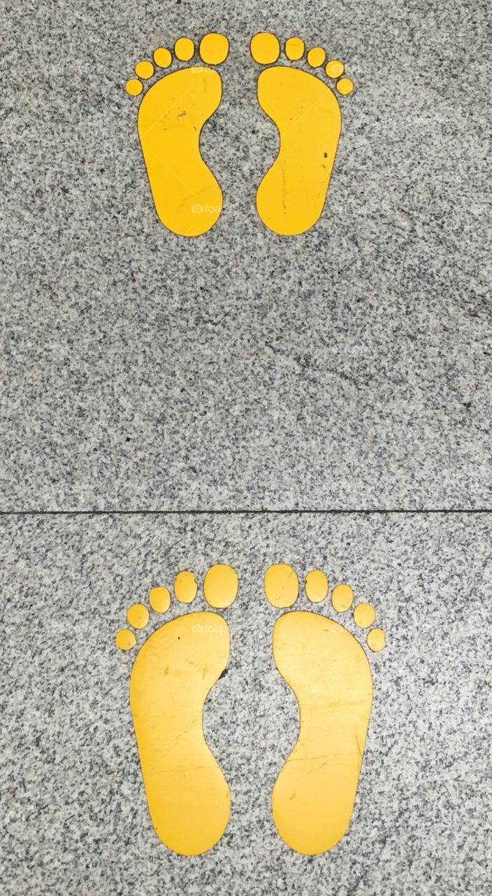 Yellow Painted Feet on Pavement 