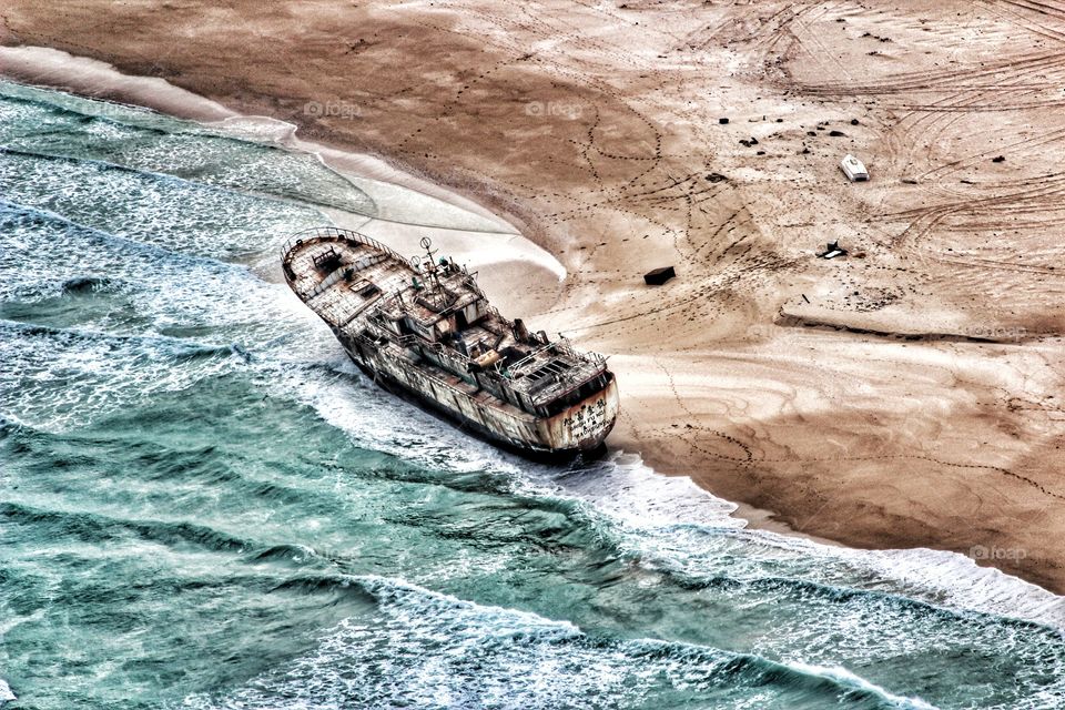 One of many merchant ships that were taken hostage by pirates long ago and were never paid a random for and were left to decay on the beautiful shores of the Somalia coastline in Africa