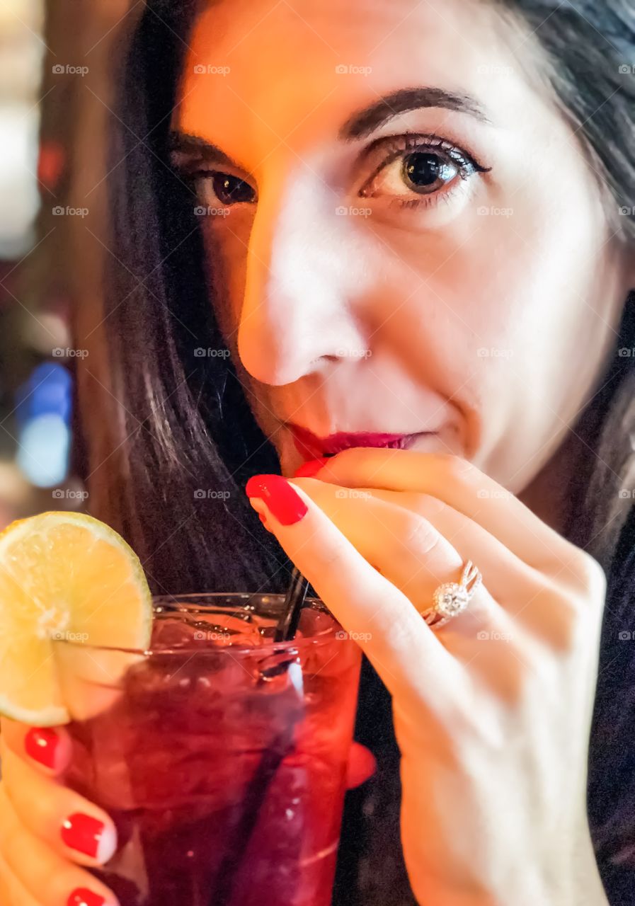 Young girl close up portrait with a drink and focus on engagement ring. 