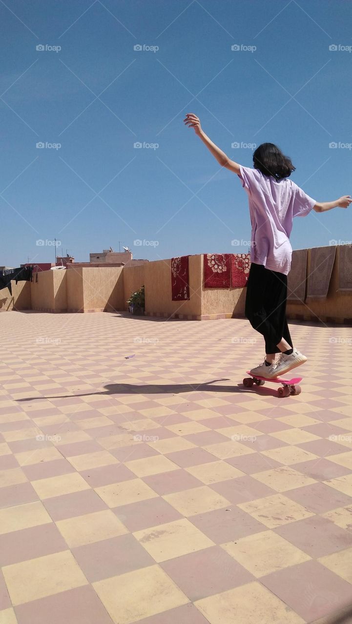 Young girl playing with skate board.