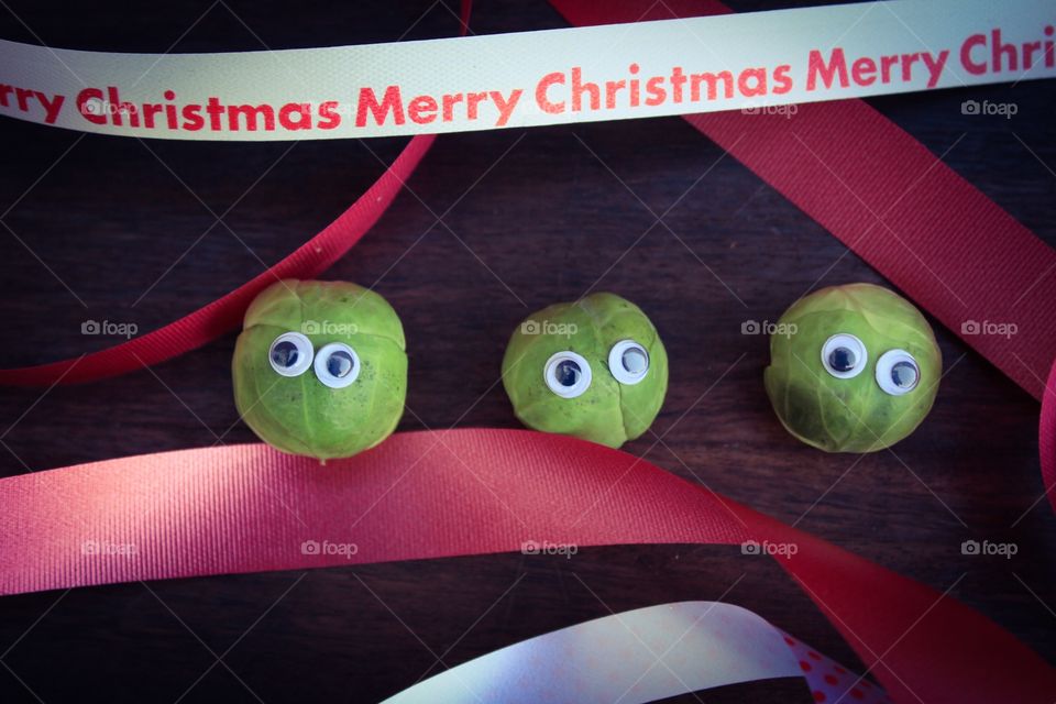 Three brussel sprouts with eyes with Christmas ribbon