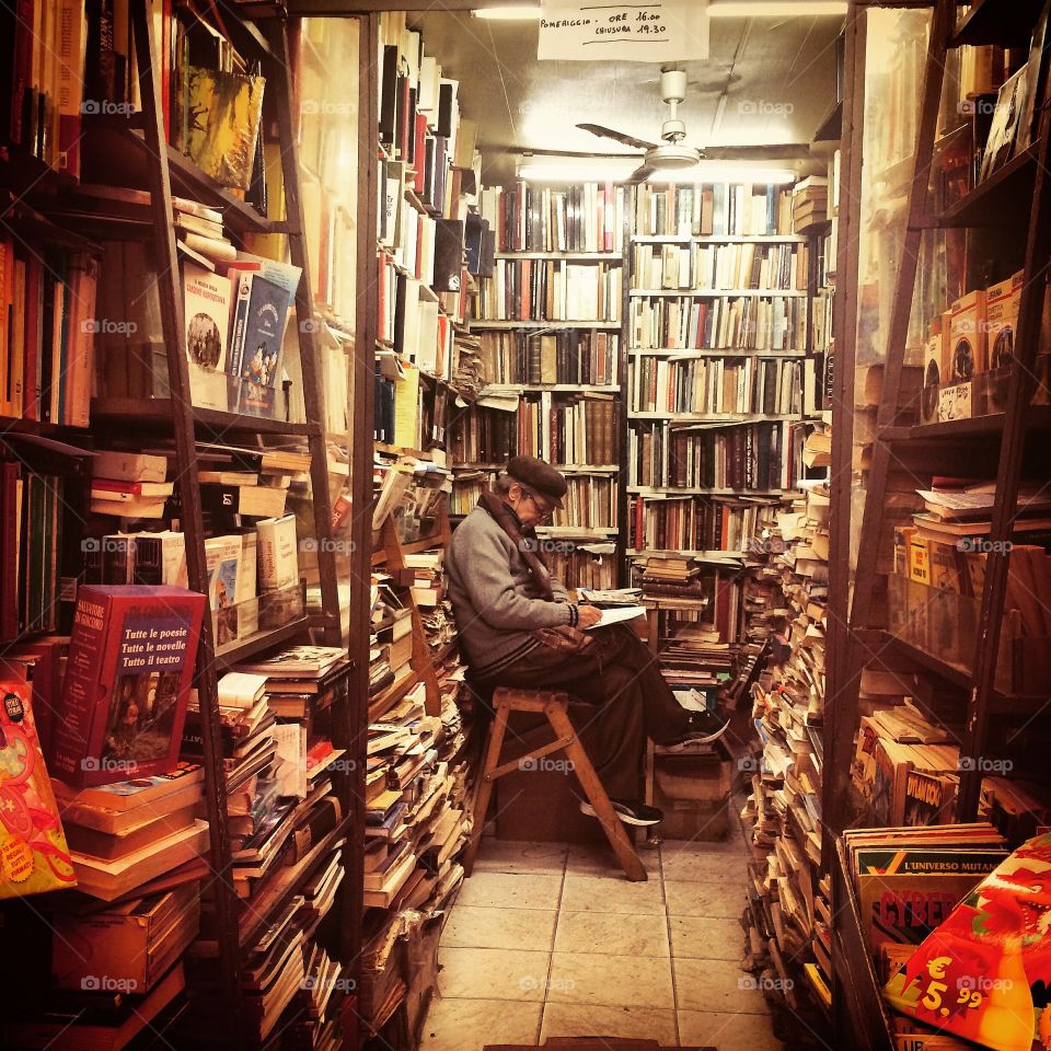 An old man reading books in his library uyennguyen95