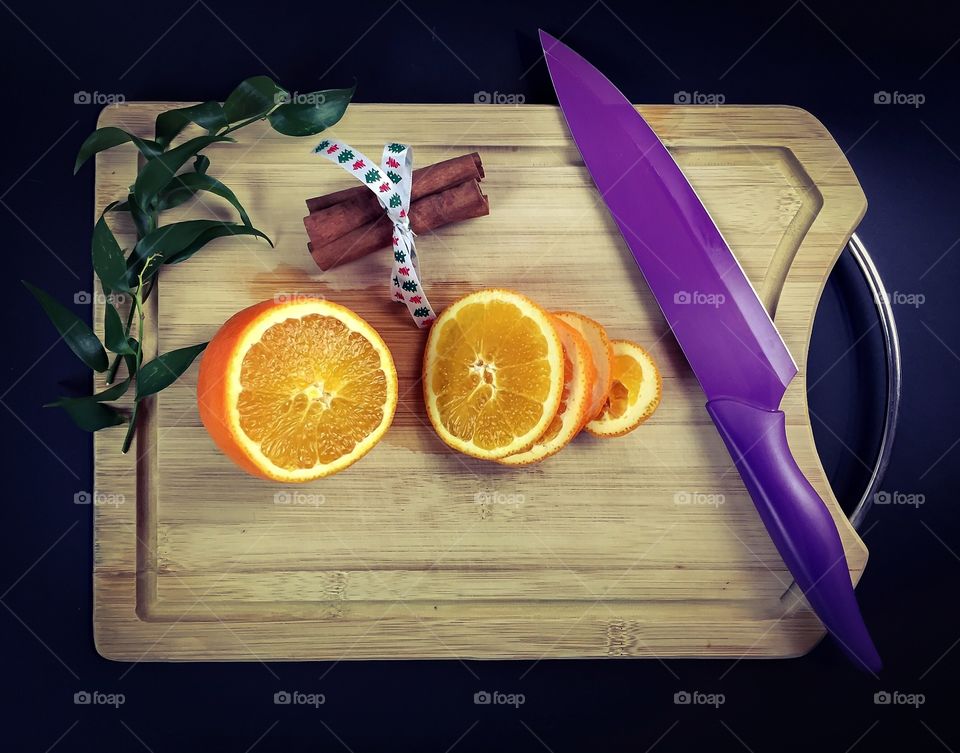 Orange fruit slices with cinnamon on chopping board
