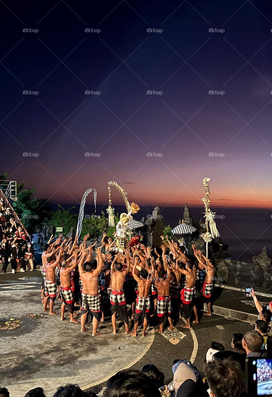Traditional kecak dance or fire dance in Bali, Indonesia. The performance take place in a temple with beautiful sunset at the background.
