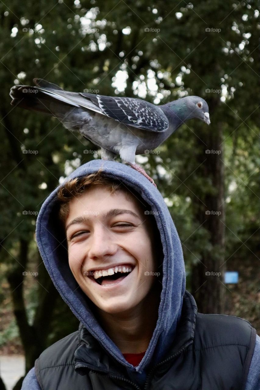 Laughing boy with a dove on his head