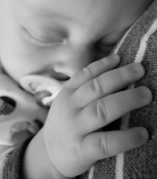 Baby sound asleep on his mother's chest. Snuggle time.