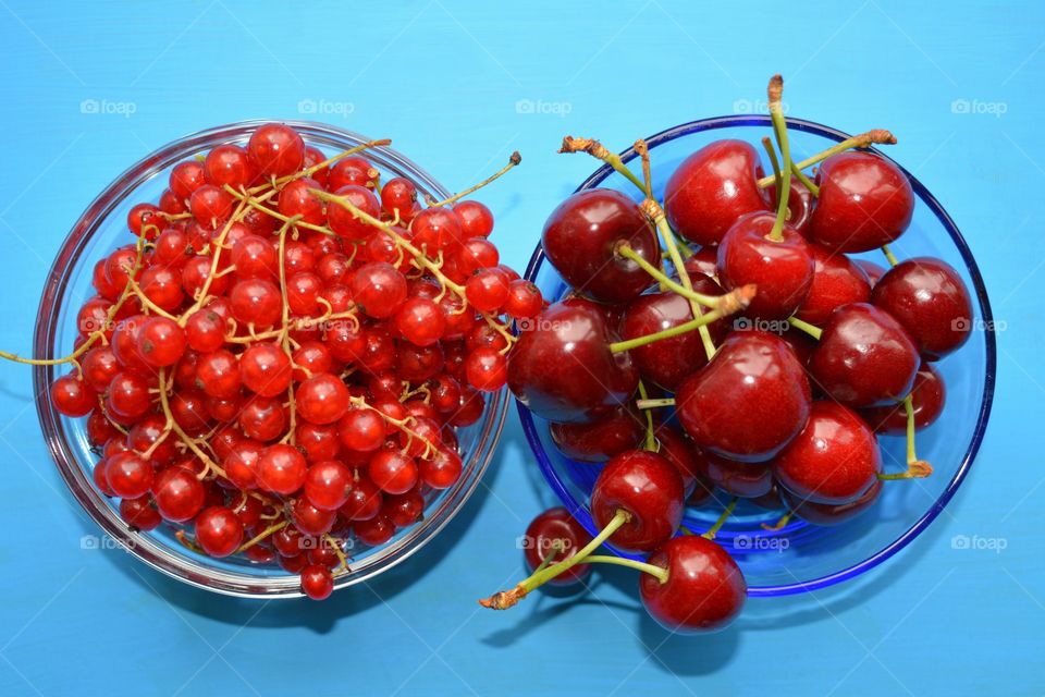 red berries summer food on a plate in the hand green background