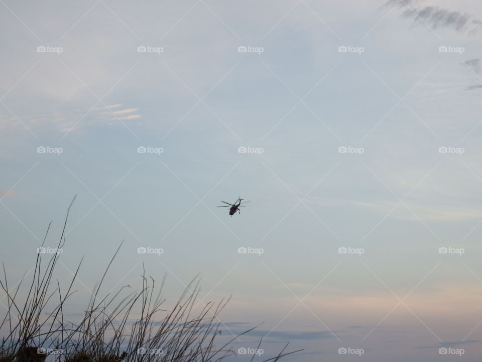 Helicopter over beach at sunset
