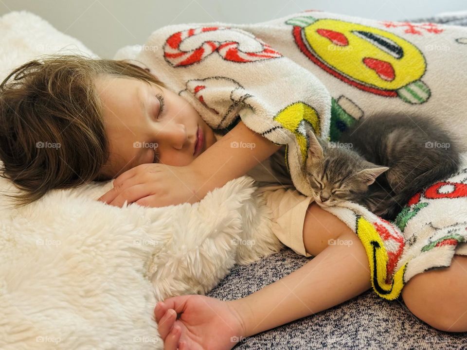 Little boy sleeping with kitten