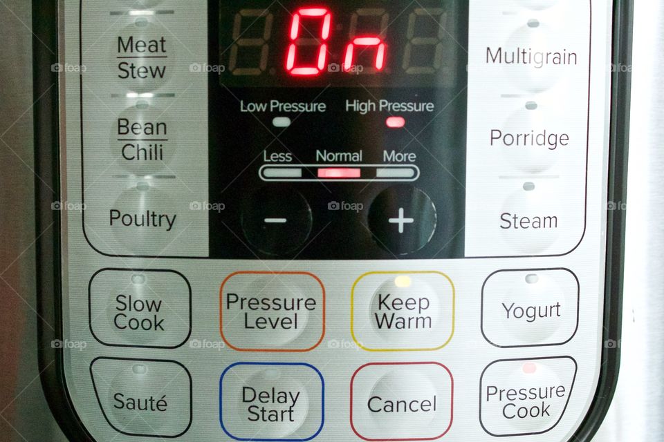 Control panel of an electric pressure cooker showing that it is plugged in and ready to be programmed 