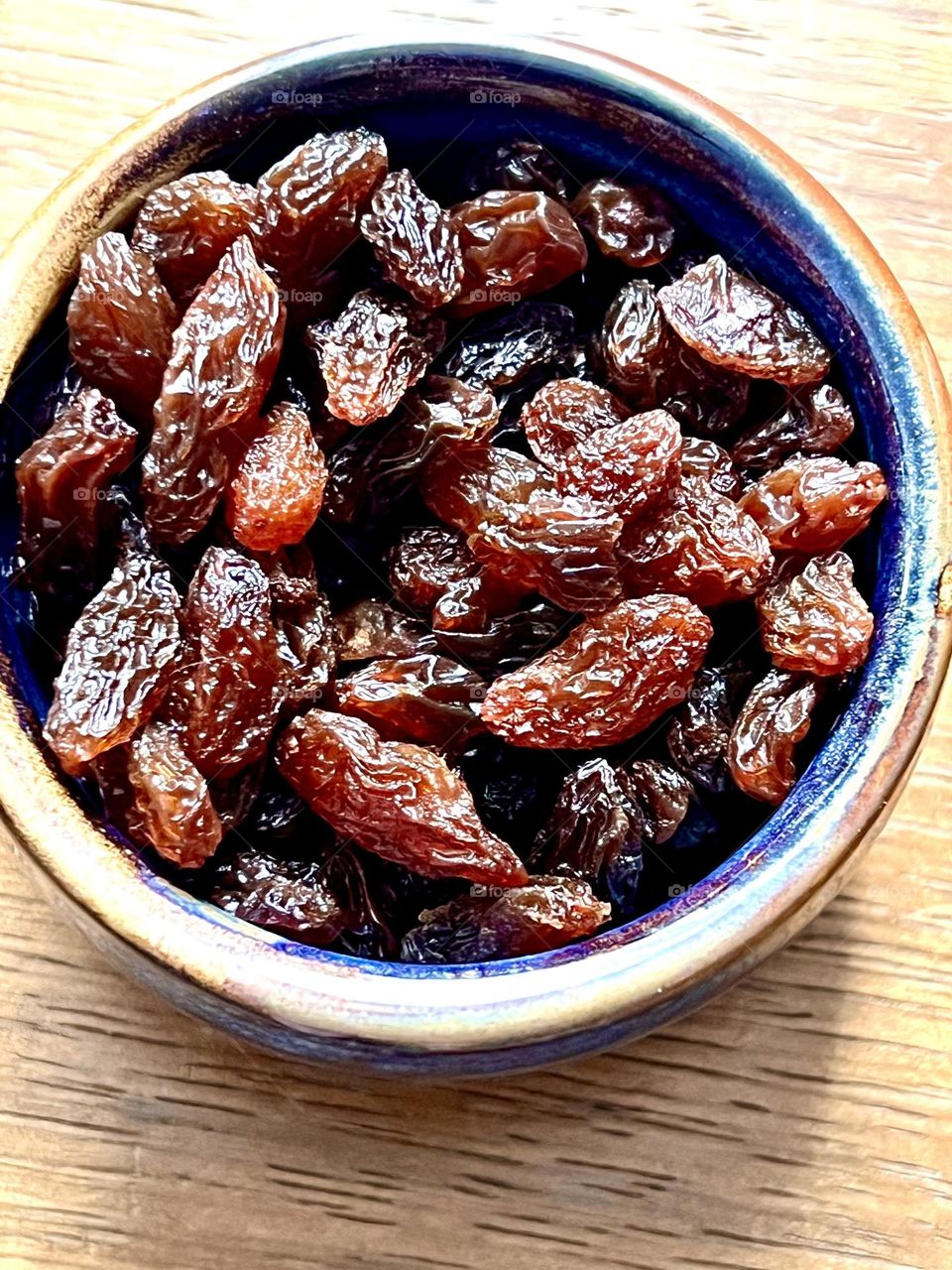 The photo shows a plate filled with raisins. 