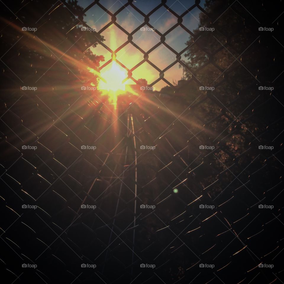 Sunrays through a railway fence
