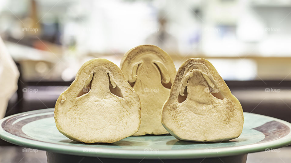 Straw mushroom cut half on a plastic plate green.