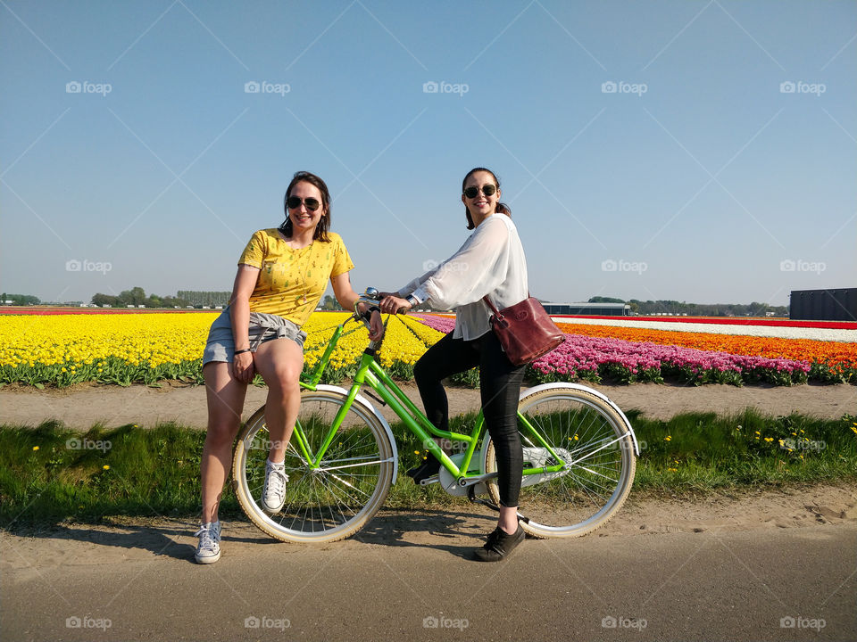 Girls riding a bike in the tulip fields
