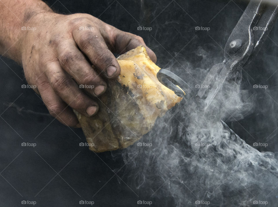 Working Hands, Blacksmith putting bees wax on metal to give a metal good finish